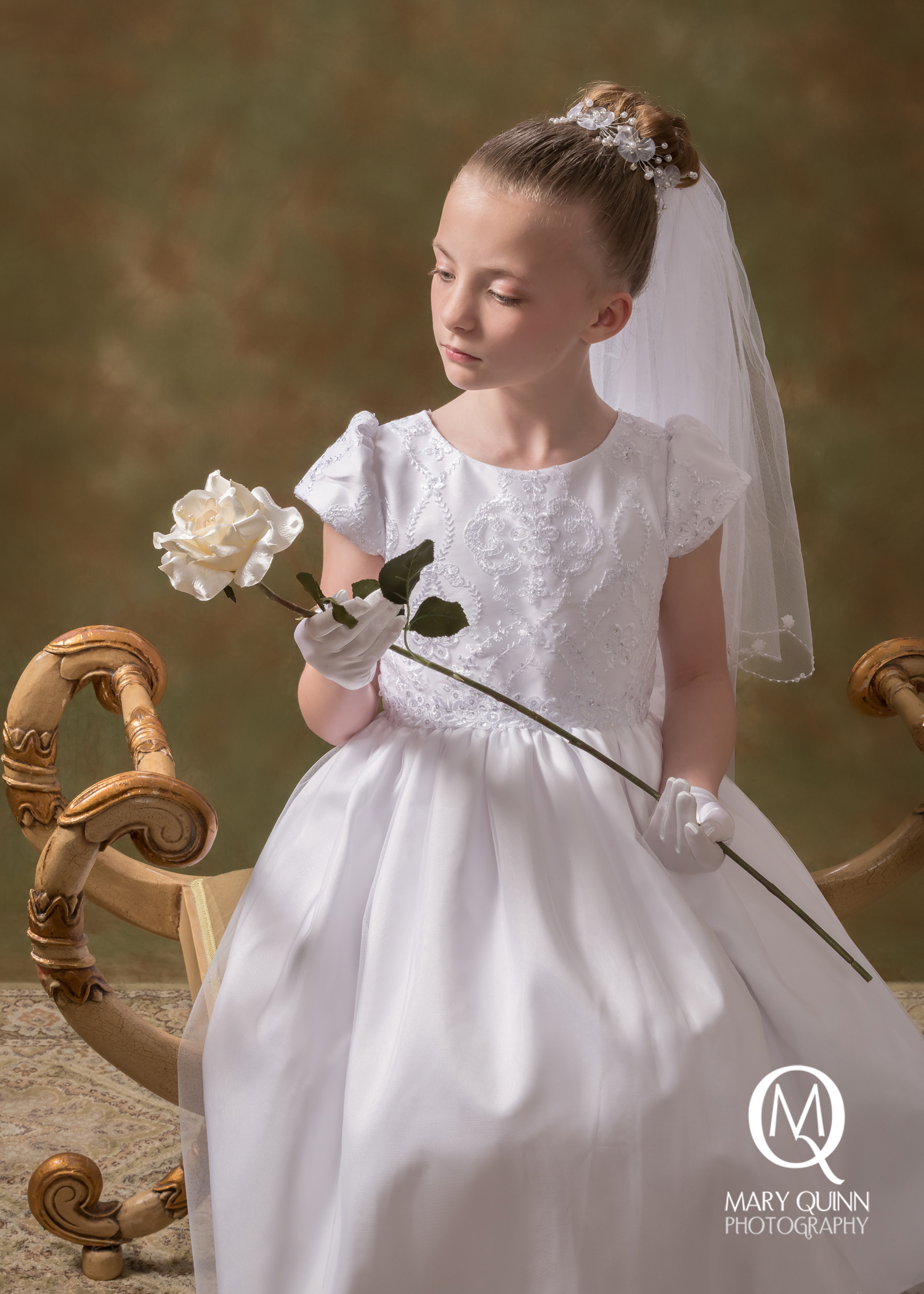 Image of a girl holding a rose for her Communion session in a South Jersey studio with Mary Quinn.