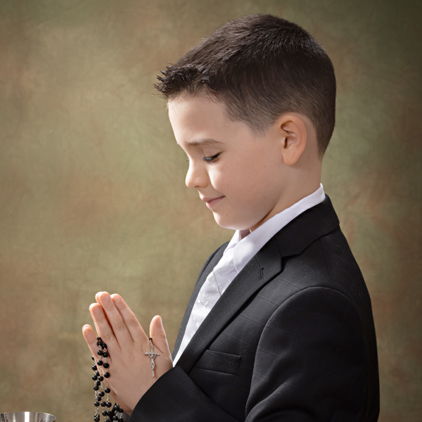 First Communion boy praying with rosary in South Jersey photography studio with Mary Quinn.